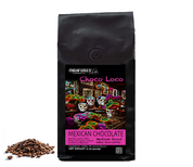 A bag of Mexican Chocolate Flavored Medium Roast coffee beans with a colorful design, accompanied by whole coffee beans