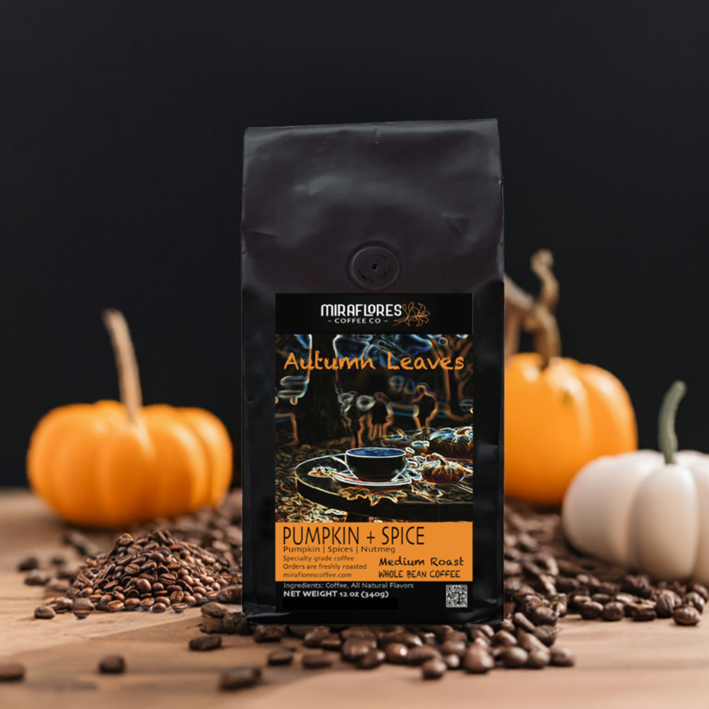 Bag of coffee beans of Autumn Leaves Pumpkin Spice Flavored Blend coffee from Miraflores Coffee showing flavor notes of pumpkin, spices and nutmeg. Bag shows art with cup of coffee an outdoor cafe with falling leaves around. Bag is on wooden table with pumpkins and roasted whole beans 